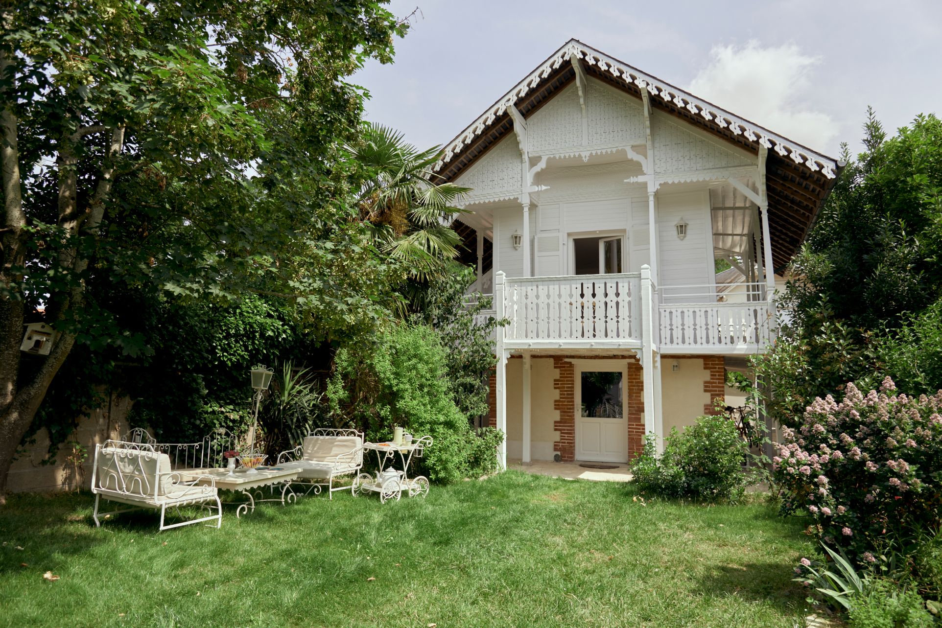 Chalet Olivet blanc dans un style architecturale suisse, avec un jolie jardin champetre