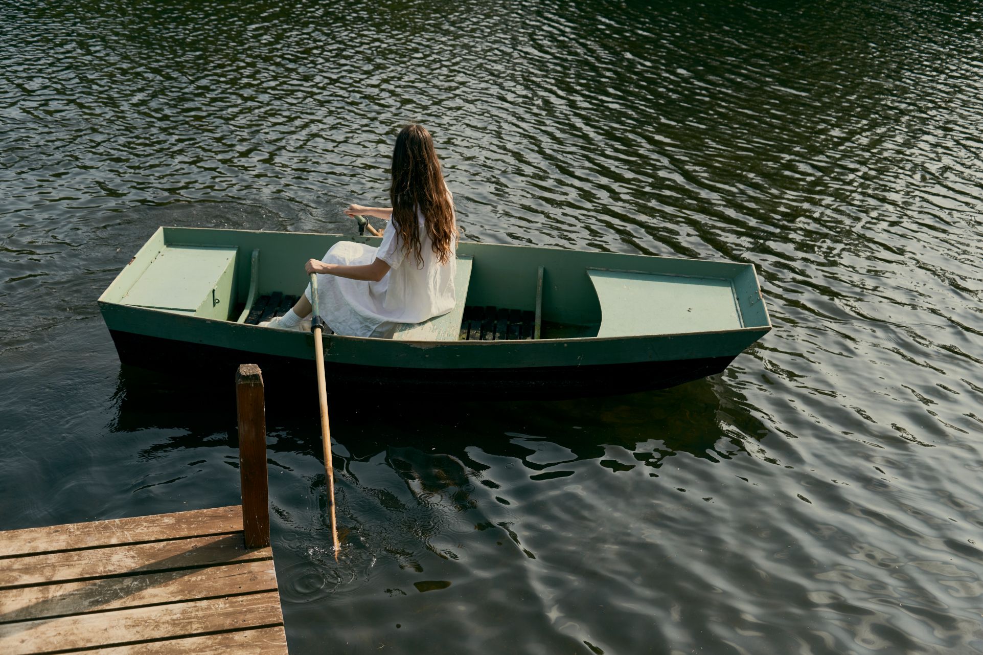 Ponton au bord du loiret avec une barque en bois , une femme en robe blanche rame
